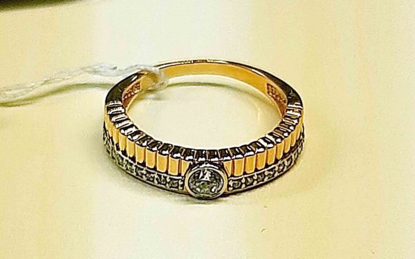 фото Золотое кольцо КВ2705 лежит на желтой подло.ке