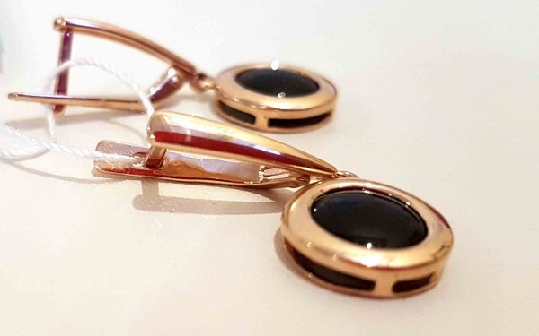 фото Золотые сережки с черной эмалью СВ2158 лежат на столе